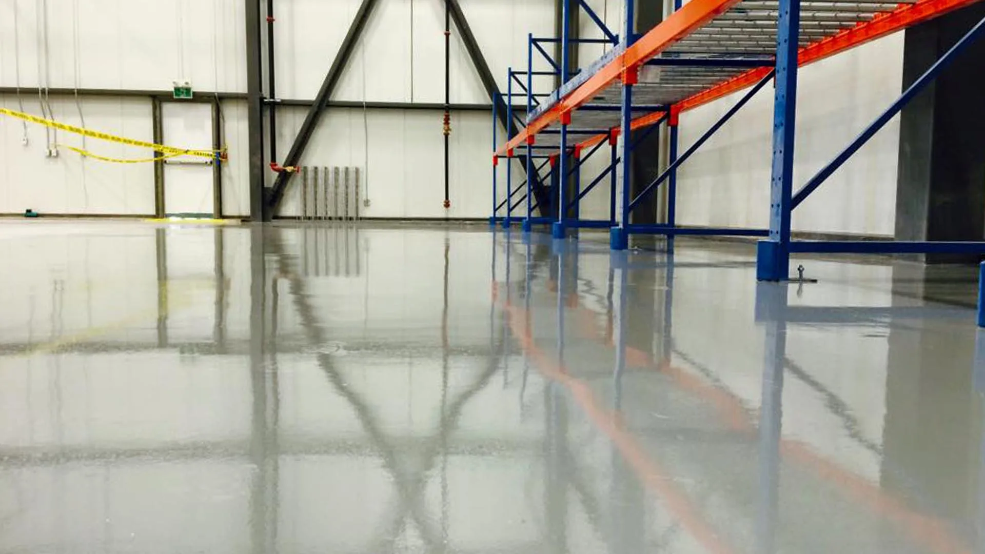 Glossy light-grey epoxy coating beneath industrial warehouse racks